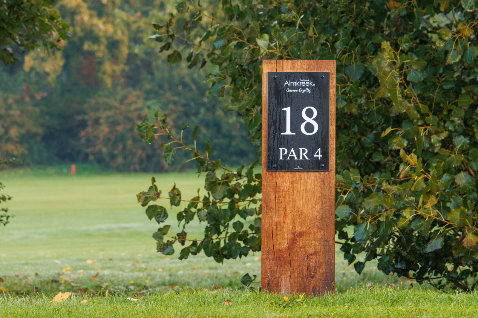 Bord van hole 18 par 4 op Golfpark Almkreek tussen het groen