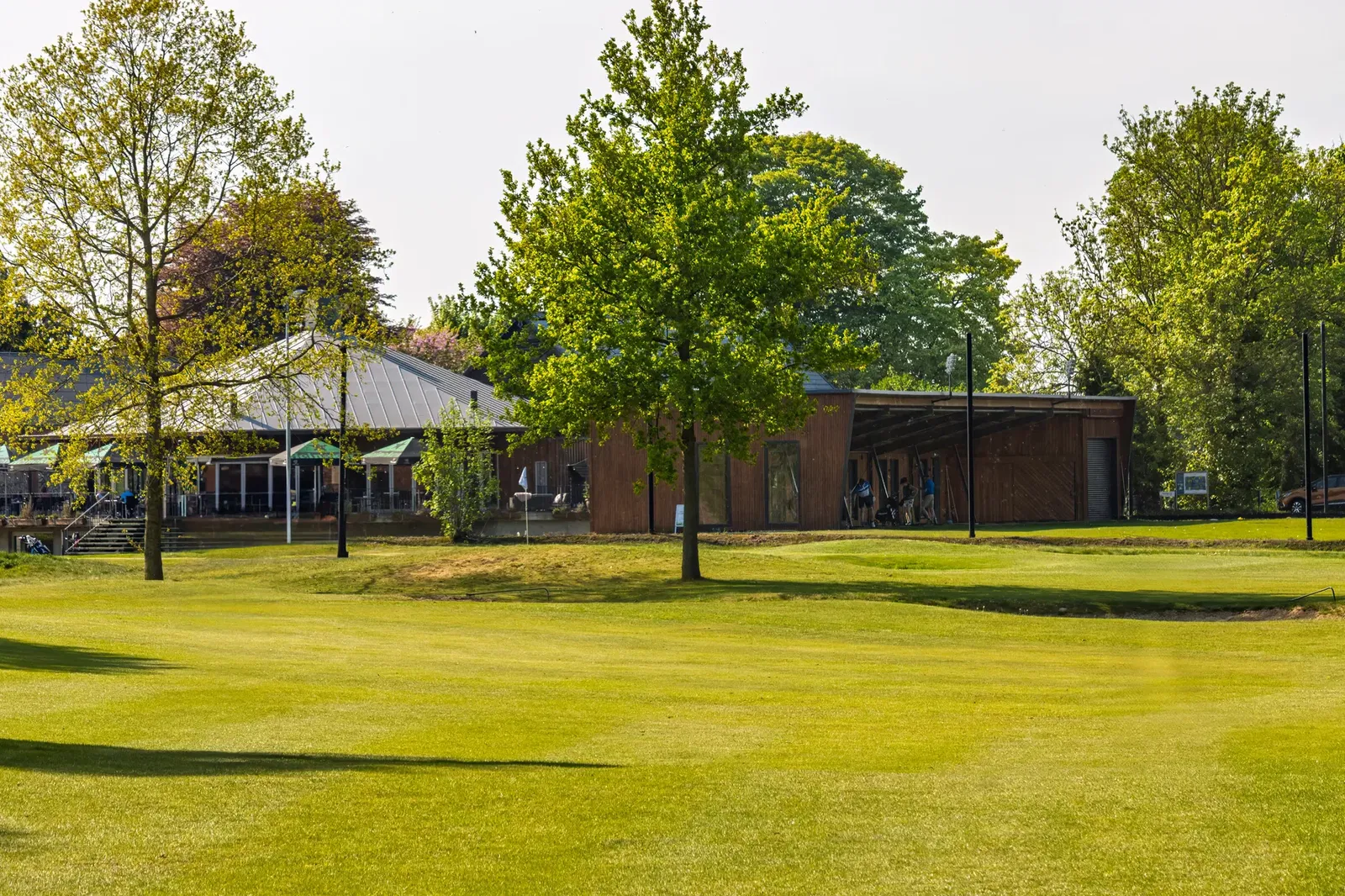 Clubhuis en golfbaan van Golfpark Almkreek in een groene omgeving