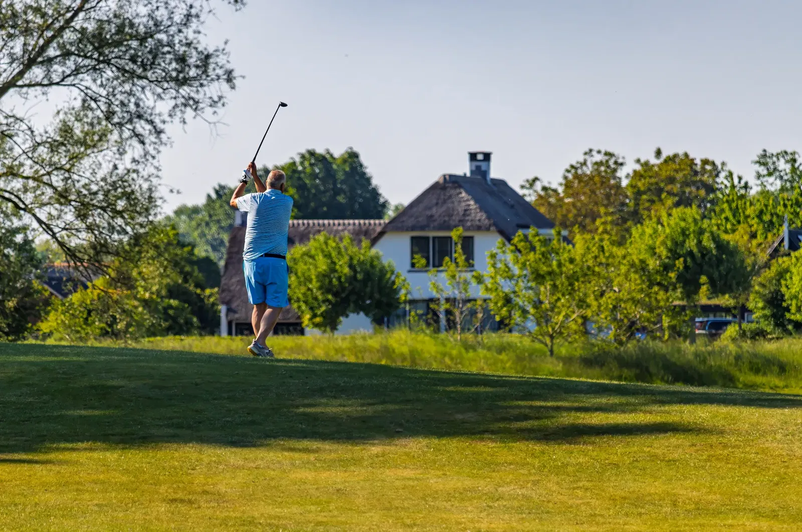 Golfer slaat af op de 18 holes baan van Golfpark Almkreek in zomerse omstandigheden