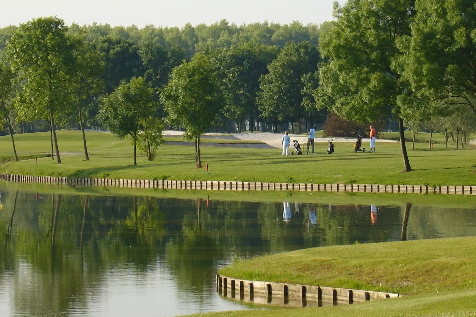 Golfers op de 27 holes golfbaan van Golfpark De Purmer met waterpartijen en groen