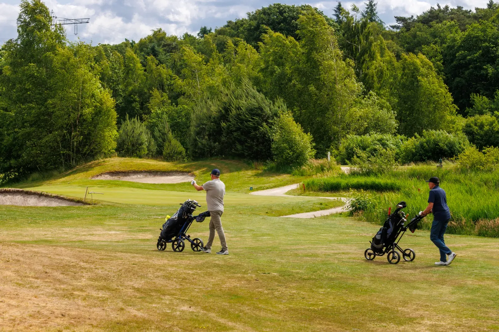 Golfers op weg naar de volgende afslagplaats op Gendersteyn, Veldhoven